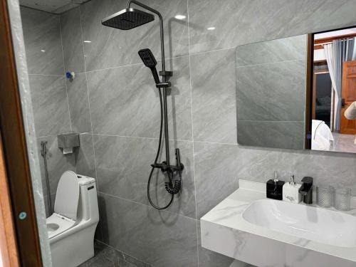ein Badezimmer mit Dusche, Waschbecken und Toilette in der Unterkunft Phương Anh Hotel in Mèo Vạc