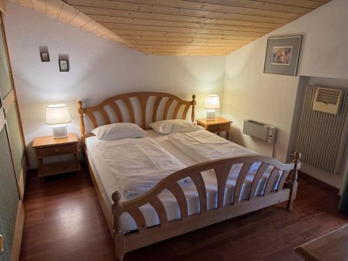 een slaapkamer met een groot bed met twee nachtkastjes bij Sport Hotel Astoria Residence in La Villa