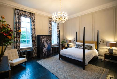 a bedroom with a bed and a chandelier at Wren Place Hall in Barnsley