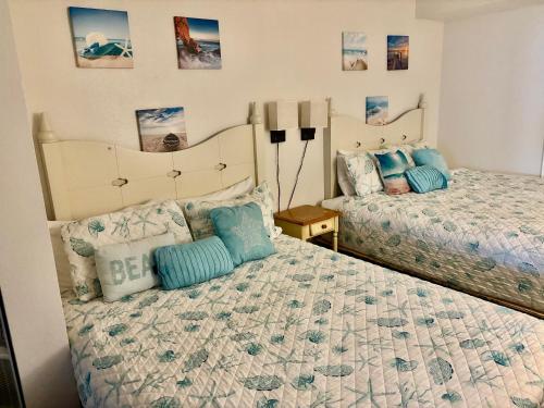 a bedroom with two beds with blue pillows at Ocean Walk Resort - Dramatic Ocean Front View in Daytona Beach