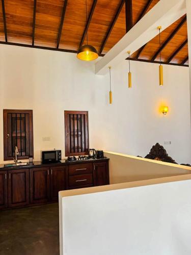 a kitchen with wooden cabinets and a counter top at Legacy Weligama - 8 min to Weligama Beach in Weligama