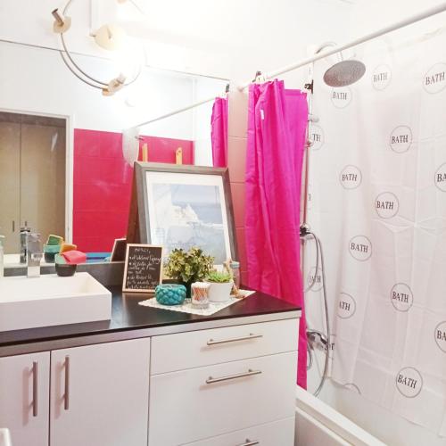 La salle de bains est pourvue d'un rideau de douche rose et d'un lavabo. dans l'établissement Book A Rest Paris, à Longjumeau