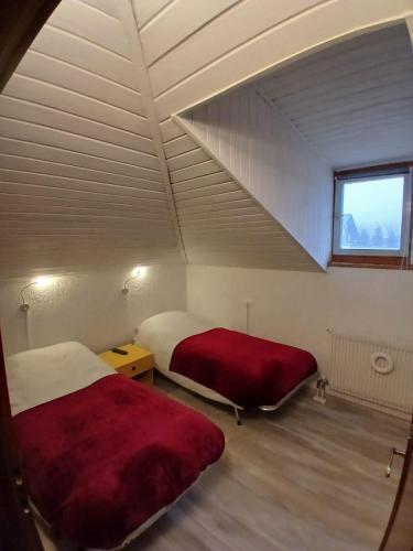 a room with two beds and a window in a attic at Ampia Mansarda a Dimaro in Val di Sole in Monclassico
