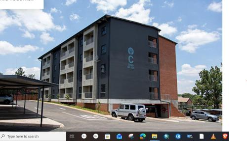 ein Gebäude mit einem weißen LKW auf einem Parkplatz in der Unterkunft LSG Delta in Centurion