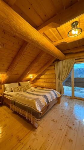 a bedroom with a large bed in a wooden ceiling at Derevo House in Yasinya