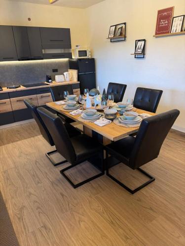 a table with chairs and plates on it in a kitchen at Premiere Chalet in Vărşag