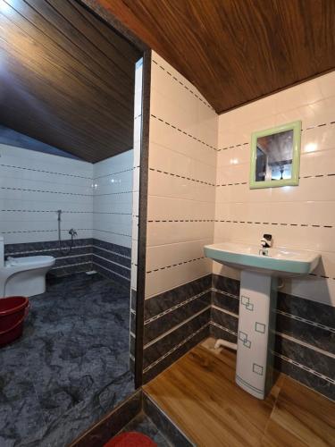 a bathroom with a sink and a toilet at Ayodhya Home stay in Māvalli