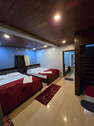 a bedroom with two beds and a hallway with a mirror at Ayodhya Home stay in Māvalli
