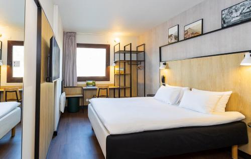 una camera d'albergo con un letto grande e un tavolo di ibis Grenoble Gare a Grenoble