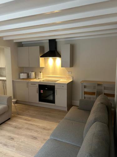 a living room with a couch and a kitchen at 15B Church Street, Bingham, Nottingham, Nottinghamshire, NG13 8AL in Bingham