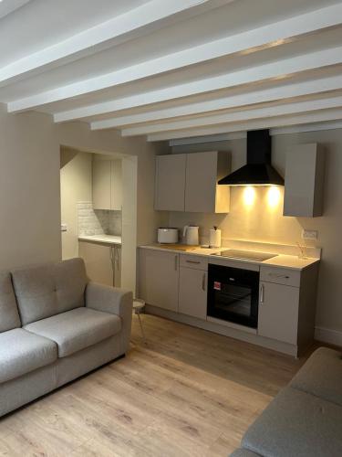 a living room with a couch and a kitchen at 15B Church Street, Bingham, Nottingham, Nottinghamshire, NG13 8AL in Bingham