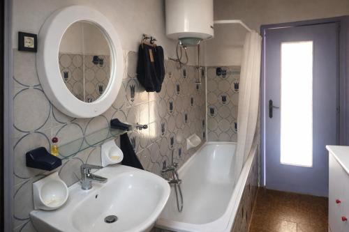 een badkamer met een wastafel, een bad en een spiegel bij Mansarda Panoramica nelle Valli di Lanzo Camino & Silenzio in Ceres