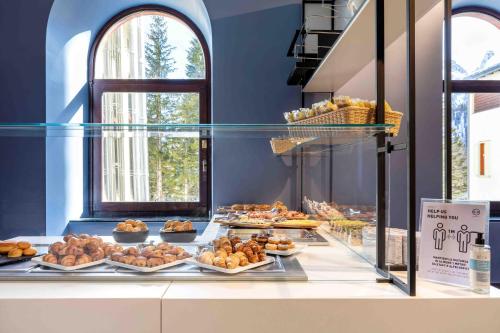 a bakery with many different types of pastries on display at B&B Hotel Passo Tre Croci Cortina in Cortina dʼAmpezzo