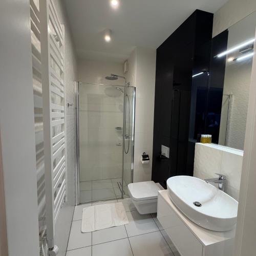 a bathroom with a shower and a sink and a toilet at Blue Reef 6th Floor Sea View in Międzyzdroje