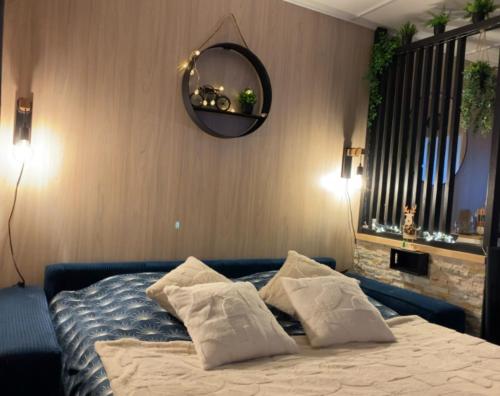 une chambre avec un lit avec des oreillers et un miroir dans l'établissement le petit gîte de mag, à Plouha