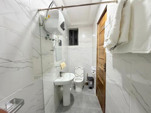 ein weißes Badezimmer mit Toilette und Dusche in der Unterkunft A Serene home away from home in Damba