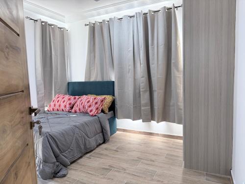 ein Schlafzimmer mit einem Bett mit rosa Kissen darauf in der Unterkunft A Serene home away from home in Damba