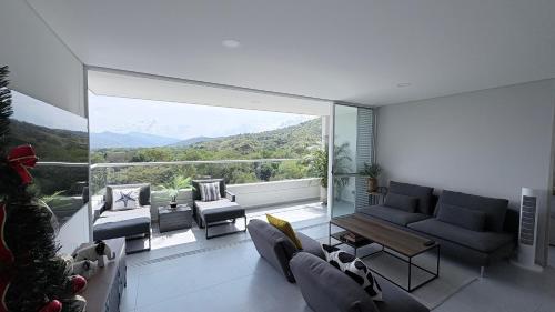 a living room with a couch and a large window at Citadela Di Sole Tropical Escape in Santa Fe de Antioquia