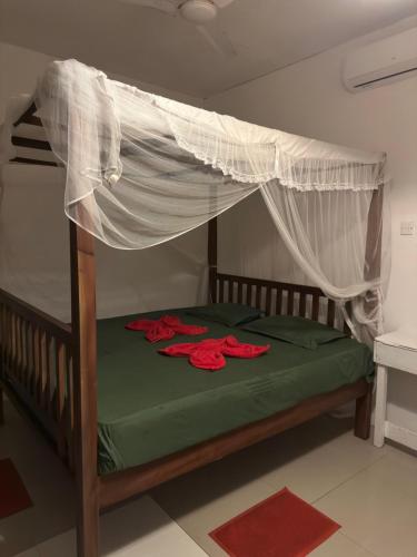 a bedroom with a bed with a mosquito net at Seasong Rooms in Unawatuna