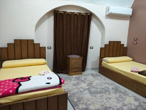 een kamer met 2 bedden en een dressoir. bij Sunrise in Abu Simbel