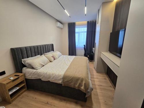een slaapkamer met een bed en een flatscreen-tv bij Penthouse Nusha Apartments in Doesjanbe