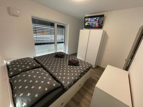een kleine slaapkamer met een bed en een televisie bij Apartmán Raj in Žilina
