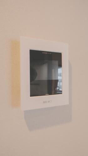 a microwave on a wall in a room at AURA YUZAWA Apartment Hotel - 1Bedroom Apartment with Living Dining Kitchen Sleeps 2 to 4, Bedroom with 2-Double Bed, Living Room with 1-Sofa Bed in Yuzawa