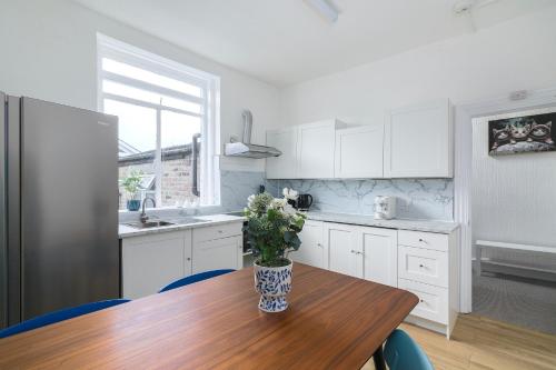 a kitchen with a wooden table with a vase on it at Camden Central 4-Bedroom Flat -12 Guests in London