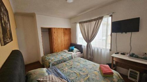 a hotel room with two beds and a window at Turismo Quintamar 5 poniente 431 Viña in Viña del Mar