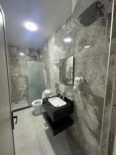 a bathroom with a sink and a toilet and a shower at Happy Beach Castel for Apartment قلعة شاطئ السعادة للشقق المفروشة in Aqaba
