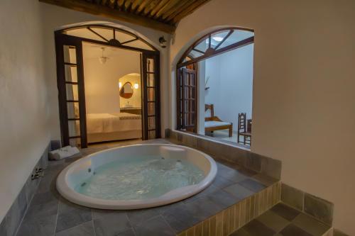 een groot bad in een kamer met een slaapkamer bij Pousada Natureza in Morro de São Paulo