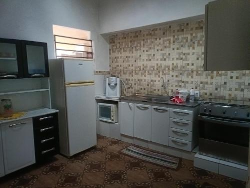 eine kleine Küche mit Kühlschrank und Spüle in der Unterkunft Casa no Centro da cidade! in Goiás