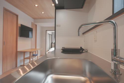 een keuken met een roestvrijstalen wastafel en een aanrecht bij AURA YUZAWA Apartment Hotel - 1Bedroom Apartment with Living Dining Kitchen Sleeps 2 to 4, Bedroom with 2-Double Bed, Living Room with 1-Sofa Bed in Yuzawa