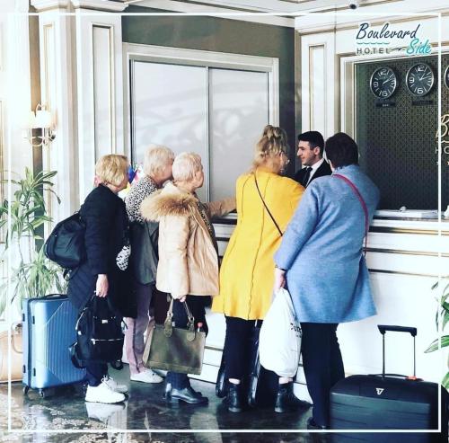 een groep mensen die voor een winkel staan bij Boulevard Side Hotel in Baku