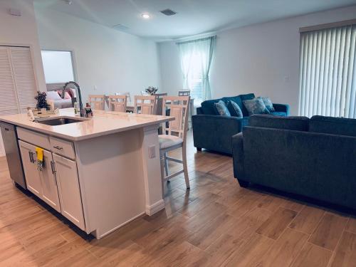 een keuken en een woonkamer met een bank en een wastafel bij Blue Mantle Charlotte Hideaway in Port Charlotte