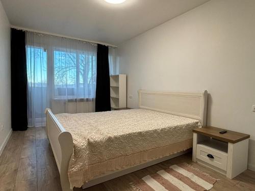 a bedroom with a white bed and a window at Cietokšņa 64 in Daugavpils