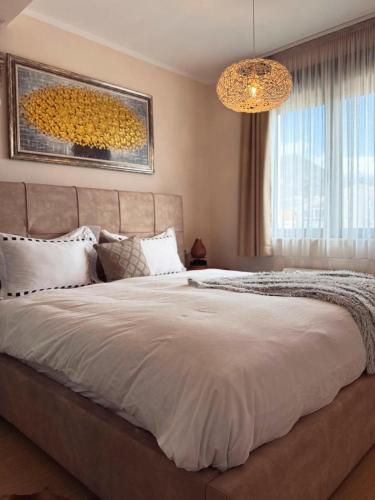 a bedroom with a large bed and a chandelier at Apartment Zoe in Tivat