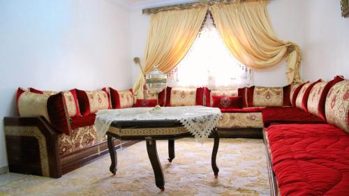 een woonkamer met een bank en een tafel bij Comfortable Apartment in Tangier 10 Min Stadium in Tanger