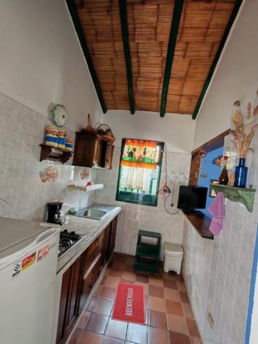 a small kitchen with a sink and a stove at Pueblito Boyacense, Hotel Boutique La Cueva de la Luna in Duitama