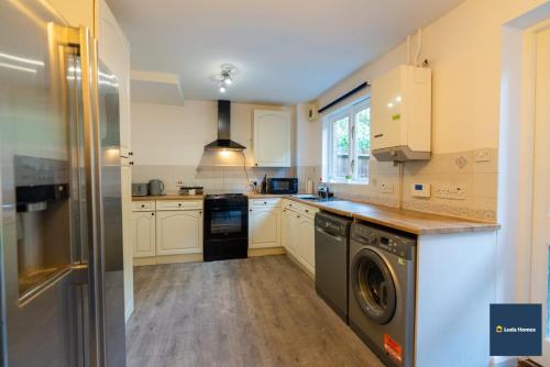 a kitchen with a washer and dryer in it at Camberley Spacious and Comfy 3 Bedroom Home, Next to Frimley Hospital with Parking in Frimley