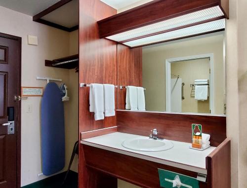 een badkamer met een wastafel en een spiegel bij Rogue Regency Inn Medford Airport in Medford