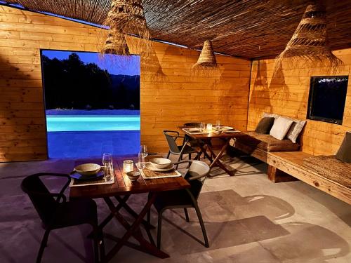 una sala da pranzo con tavolo e grande schermo di Mimosa Lodge a Girona