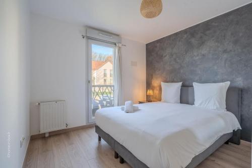 En eller flere senge i et værelse på Central and peaceful apartment 10 min Disney - 4P