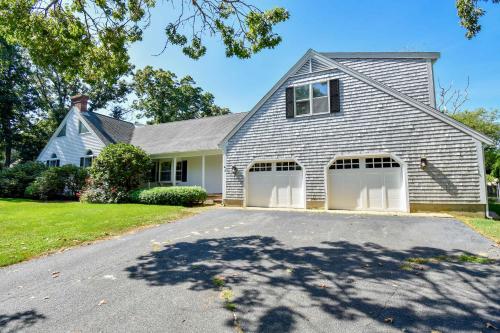 een huis met twee garagedeuren op een oprit bij Private pool 3 mins to Skaket Beach in Orleans