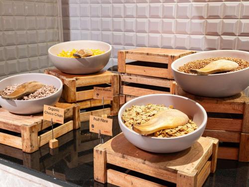 eine Ausstellung von Schüsseln mit Essen auf Holzkisten in der Unterkunft ibis Dubai One Central in Dubai