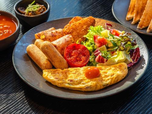 einen Teller Essen mit Omelett und Salat in der Unterkunft ibis Dubai One Central in Dubai