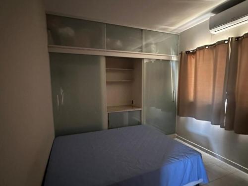 une petite chambre avec un lit avec un drap bleu dans l'établissement Casa Guriri Top - Piscina, Praia e Churrasqueira, à Guriri