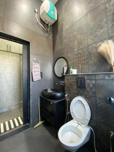 une salle de bains avec toilettes, lavabo et miroir dans l'établissement Chahat Villa, à Palampur