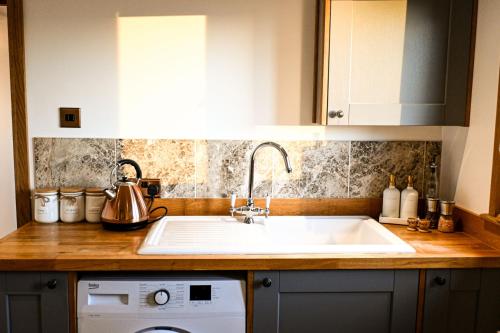 a kitchen counter with a sink and a dishwasher at Pooh Corner in Hythe