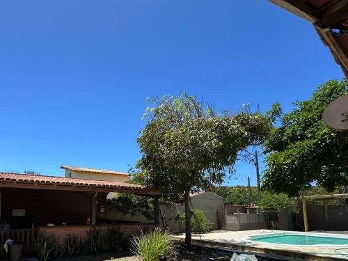a house with a tree and a swimming pool at Casa Fantástica in Guriri